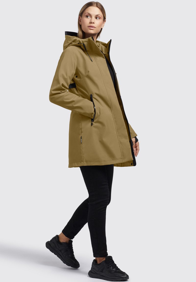 Veste khaki résistante à l'eau avec capuche, fermeture éclair sur le devant et poches latérales, agrémentée d'une doublure intérieure noire et d'un design élégant.