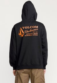 Sort hætte sweatshirt med et orange grafisk tryk på ryggen. Fremstillet af bomuld, har den ribkantede manchetter og kant. Minimalistisk design.