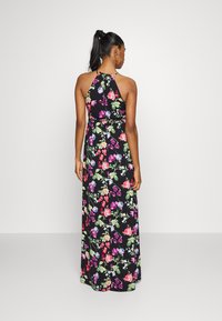 Vestido maxi com decote halter, fundo preto e estampado floral colorido. Apresenta um cintura ajustada e saia fluida.