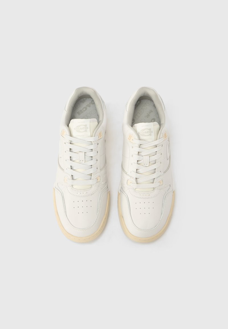 White leather sneakers with a round toe, textured accents, and a light-colored rubber sole. Features perforations and flat laces.