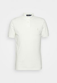 Vit pikétröja av bomull, med en tvåknappsslutning, vikta ärmar och en liten broderad logotyp på bröstet.