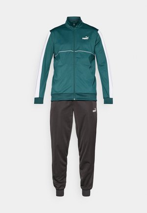Grøn træningsjakke med hvide accenter og lynlås, parret med sorte træningsbukser med elastiske manchetter og logo-detaljer. Fremstillet af glat stof.