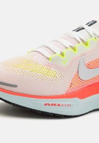 Chaussure de course légère avec un design superposé en rose, jaune et orange. Dotée d'une tige en mesh, d'un amorti visible et d'une semelle extérieure noire.