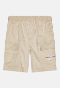 Beżowe krótkie spodenki typu cargo z elastycznym pasem, bocznymi kieszeniami, kieszeniami na patki oraz haftowanym logo Calvin Klein Jeans na lewej dolnej nodze.