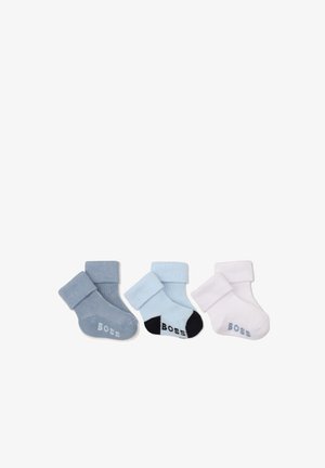 Trois paires de chaussettes pour bébé pliées en gris, bleu clair avec talons noirs et blanc, chacune avec le mot "Boss" sur la semelle.