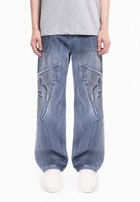 Svetlo modre kavbojke z ohlapnimi hlačnicami, obrobljene z izrazitim cikcak šivom in raztrganimi robovi. Prijeten oblikovalski slog z dvema sprednjima žepoma.