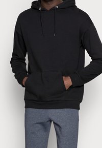 Sudadera negra de mezcla de algodón, con un bolsillo tipo canguro en la parte delantera, capucha con cordón y puños acanalados en el dobladillo y las mangas.