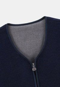 Gilet en polaire marine avec un intérieur gris, design en V, et une fermeture éclair dotée d'une tirette ronde. Texture lisse et matériau chaud.