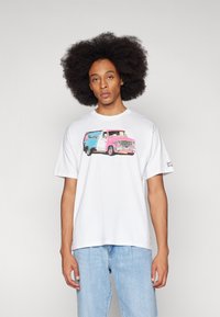 Tricou alb din bumbac, cu un grafic colorat ce reprezintă o dubiță vintage în nuanțe de albastru și roz. Croială lejeră, cu mâneci scurte și guler rotund.