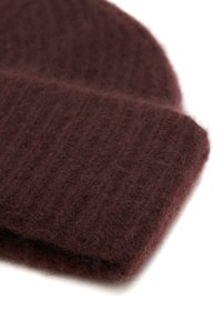 Bordeaux gebreide beanie van zachte wol. Heeft een ribbelstructuur en een omgeslagen rand voor extra warmte en comfort.