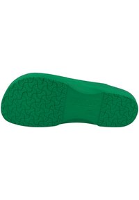 Green rubber shoe sole featuring a textured pattern with wave-like designs and embossed brand name, with a smooth edge and rounded shape.