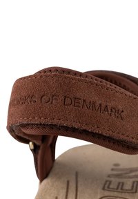 Ruskea mokkanahkainen sandaalihenkseli, jossa on kohokuvioitu teksti "DENMARKIN SANDAALIT." Pehmeä pinta, kaareva muoto ja sauman yksityiskohdat reunoilla.