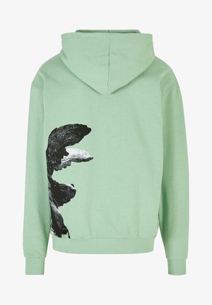 Peen roheline kapuutsiga särk, mille seljal on suur must-valge graafiline kujundus, pehme kangas, pikad varrukad ja ees kangaroo-tasku.