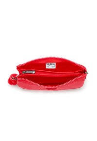 Red zippered wallet with a small pom-pom detail. Interior features a bright red lining and a separate zippered compartment. Smooth texture.