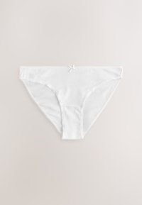 Biele bavlnené dámske bikini nohavičky s malou ozdobnou mašličkou na prednej stredovej časti pásu, uložené na rovnej ploche na svetlom pozadí.