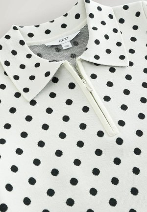 Valge kraega pullover mustade täppidega, millel on poollukuga sulgur ja sooniktekstuur. Sildil on kirjas "NEXT" ja "Valmistatud Türgis."