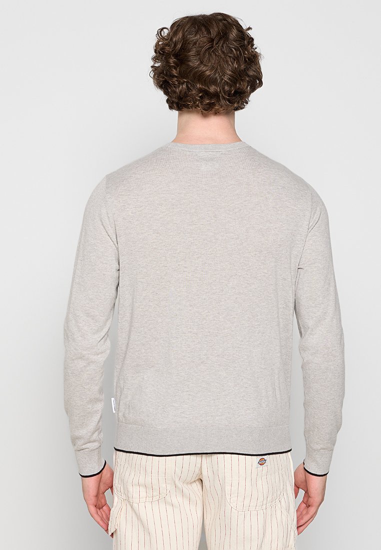 Helle graue Strickjacke mit langen Ärmeln, rundem Hals und gerippten Bündchen und Saum; zeichnet sich durch eine subtile Textur und kontrastierende dunkle Abschlüsse aus.