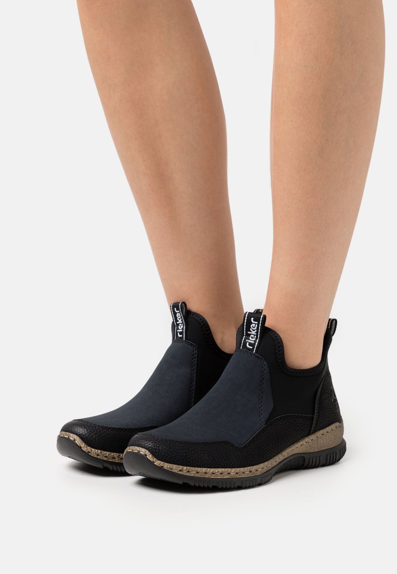 Zwart en marineblauwe enkelboots, met een gladde bovenkant, gestructureerde accenten, elastische zijpanelen en een rubberen zool met een decoratieve rand.