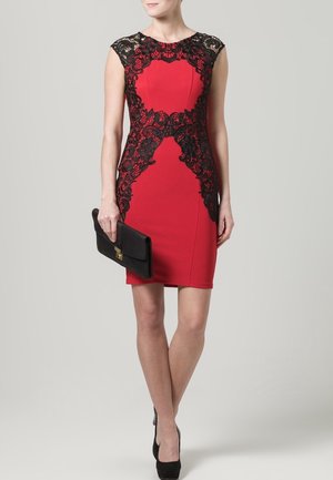Abito bodycon rosso con dettagli in pizzo nero lungo lo scollo e i lati. Tessuto liscio, design senza maniche, abbinato a una pochette nera.