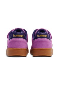 Fioletowe zamszowe trampki z granatowym akcentem, z gumową podeszwą i złotym logo na pięcie. Zaokrąglony kształt, casualowy design.