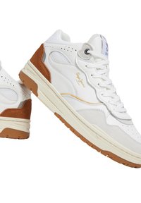White sneakers with suede brown accents, textured white mesh, and gold branding. Features a rubber sole with grip patterns and eyelet detailing.