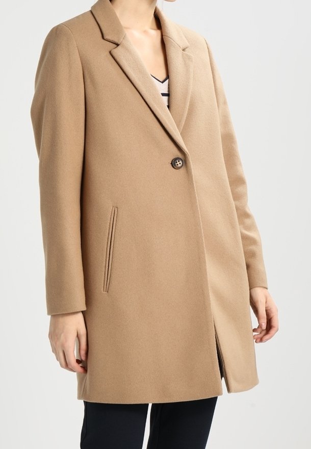 Cappotto in misto lana beige con revers a alette, chiusura con un solo bottone, tasche laterali e taglio dritto, caratterizzato da un tessuto testurizzato.