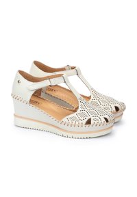 Sandali wedge bianchi in pelle con motivo perforato, design a T, dita dei piedi scoperte e cuciture decorative lungo i bordi, dotati di una suola testurizzata.