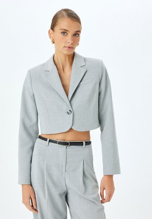 Kroppad grå blazer gjord av texturerat tyg med slagkrage, enknappsstängning och skräddarsydd passform. Matchad med högmidjade byxor.