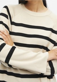 Cremfarbener Pullover mit schwarzen horizontalen Streifen; ausgestattet mit einem gerippten Ausschnitt und geknöpften Ärmeln; weicher Stoff mit einem entspannten Schnitt.