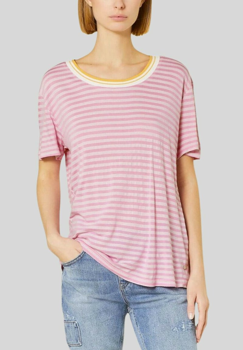 Camiseta de rayas rosa y blanca con un cuello redondo acentuado en amarillo, mangas cortas y un corte relajado, combinada con pantalones vaqueros de denim azul claro.