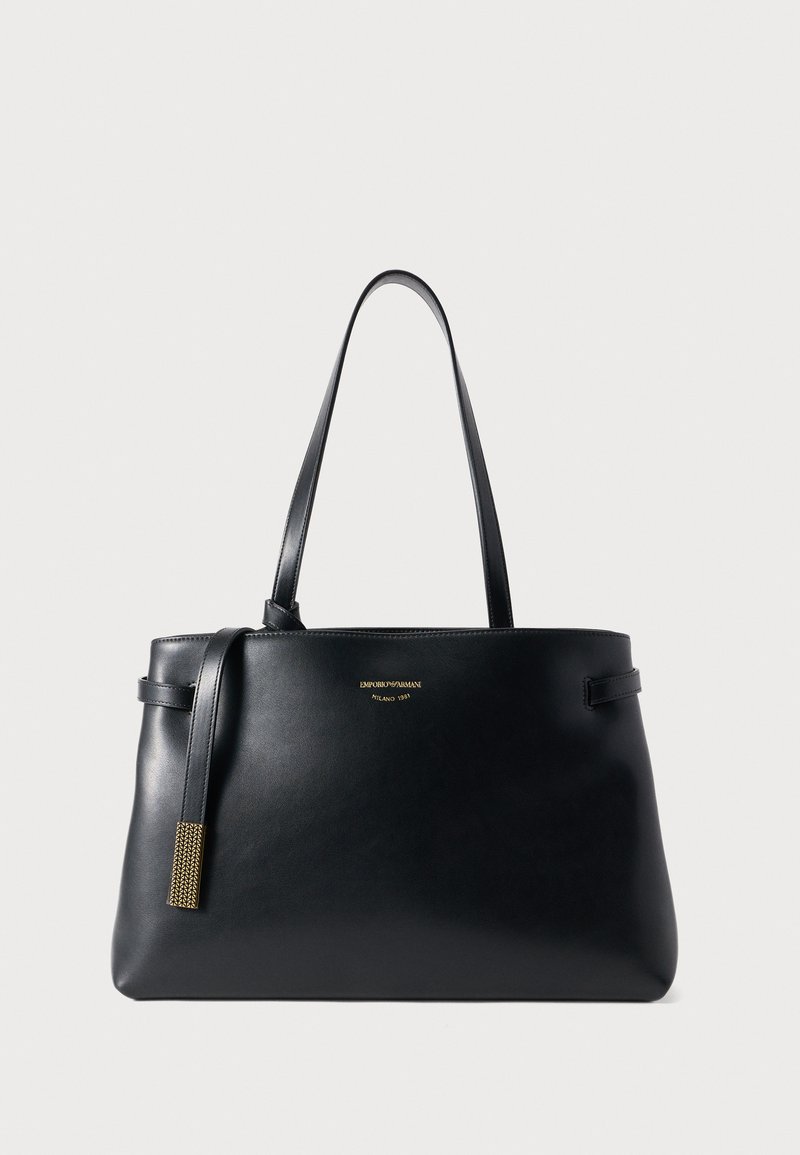 Borsa tote in pelle nera dal design minimalista, con manici doppi e un logo dorato come dettaglio. Presenta una nappina testurizzata sul lato.