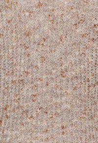 Tessuto lavorato a maglia in un delicato beige con inserimenti di rosa pallido e marrone chiaro. La texture è leggermente soffice, con un motivo di punto regolare.