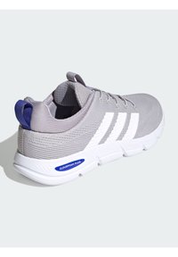 Sivá športová obuv s textúrovanou tkaninou, bielymi pruhmi a modrým akcentom. Má okrúlu špičku a odpruženú podrážku s označením "CLOUDFOAM FLEX."