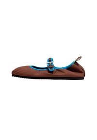 Zapato plano marrón con ribete azul brillante, correa ajustable con hebilla metálica y tirador en el talón, mostrado en perfil lateral.