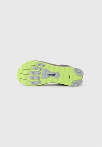 Suola di una scarpa da corsa con battistrada verde neon e grigio progettata per garantire trazione su diverse superfici.