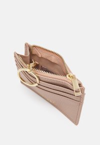 Small blush leather cardholder with gold zipper and ring, featuring multiple card slots and a textured finish. Zipper opens to reveal interior.