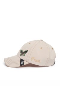 Gorra de béisbol beige con bordado de mariposa verde y "Fresh" en dorado. Cuenta con una etiqueta de logo negra y detalles cosidos en el borde.