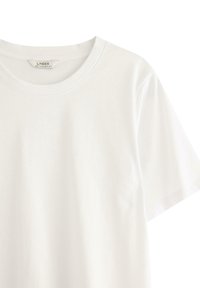 Hvid bomulds T-shirt med rund halsudskæring og korte ærmer, med en glat tekstur og uden synlige mønstre eller motiver.