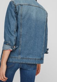 Denimjacka med en lätt avslappnad passform, ljusblå färg, uppkavlade ärmar och klassisk sömnad. Har en ryggsömn och sidofickor.