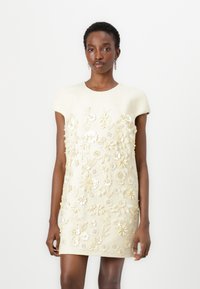Short-sleeve, cream dress with textured fabric, featuring intricate floral embroidery in white and gold accents across the front.