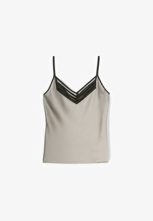 Caraco beige sans manches avec fines bretelles noires et un détail en maille rayée noire en forme de V au niveau du décolleté.