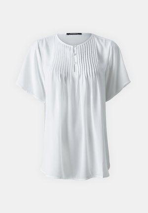 Hvid kortærmet skjorte i let stof med plisserede detaljer og fire knapper ved halsen. Blød fald og afslappet pasform.