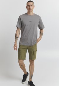 Grå bomull t-skjorte med korte ermer og en liten logo på forsiden, parret med olivenfargede cargo shorts med sidelommer og et avslappet snitt.