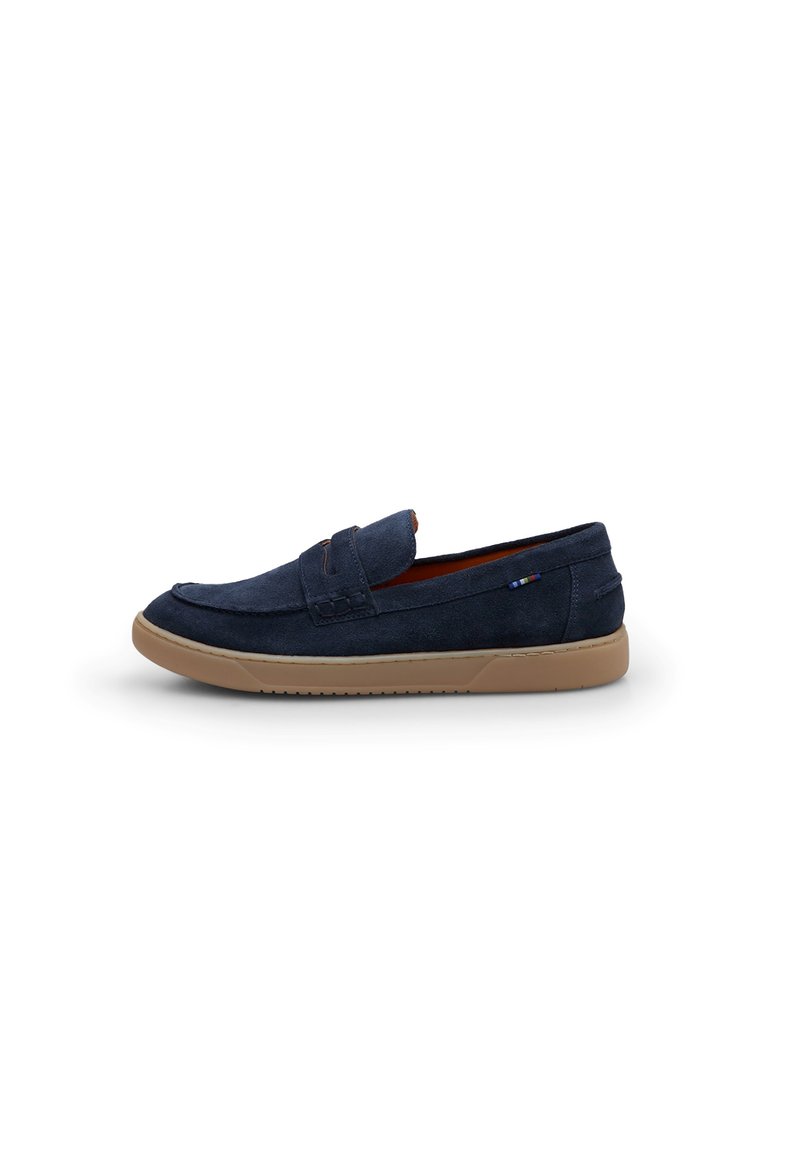 Sötétkék velúr slip-on cipő lekerekített orral, barna gumi talppal és diszkrét varrási részletekkel a felsőrészen. Simább textúra.