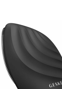 Sort hårbørste med et bølget, ergonomisk design og blød berøring. Runde kanter og gummibelagte børstehår til udredning. Mærkenavn på håndtaget.