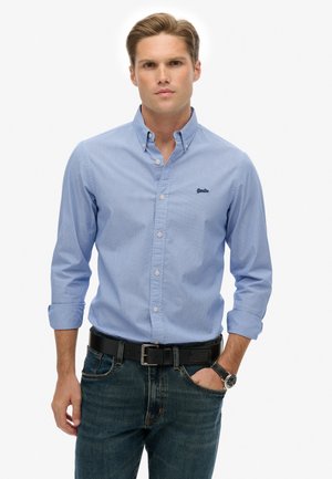  Lichtblauwe gestreepte button-up shirt met een kraag, gedragen met donkere spijkerbroek en een zwarte riem. Bevat geborduurd logo op de borst.