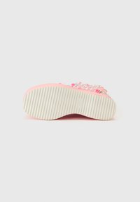 Chaussure rose avec une semelle en caoutchouc texturée et des accents décoratifs. Présente un dessus lisse et brillant ainsi qu'une semelle large et striée pour une meilleure adhérence.
