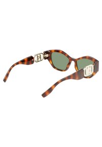 Occhiali da sole tartarugati con forma a occhio di gatto, lenti verdi e dettagli in metallo dorato sulle astine. Texture liscia in tutto.