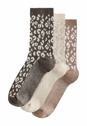 Drei Paar Socken in Braun-, Beige- und Cremetönen. Jede besitzt ein einzigartiges Leopardenmuster mit unterschiedlichen Texturen.