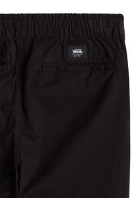 Pantalon Vans noir avec taille élastique et poches passepoilées à l'arrière, avec un patch logo Vans au-dessus de la poche droite.